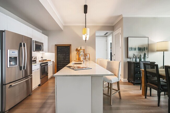 Una cocina de diseño profesional con encimeras de granito, electrodomésticos de acero inoxidable y una espaciosa isla para reuniones. - The Residence Buckhead Atlanta