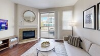 Located at 4900 S Ulster St in Denver, Colorado, this two-floor residence offers a well-appointed layout with thoughtful finishes throughout. The living room serves as a central gathering space, anchored by a granite-surround fireplace and rich hardwood flooring. A sliding glass door opens to a private balcony with open urban views, filling the room with natural light. Adjacent to the living area, the kitchen is equipped with warm wood cabinetry, granite countertops, stainless steel appliances, and a breakfast bar that connects seamlessly to the dining area. The dining space features hardwood floors and a defined, intimate setting ideal for everyday meals or entertaining. Upstairs, the bedrooms are finished with plush carpeting and vaulted ceilings that lend an airy, spacious feel. Each bedroom benefits from generous natural light through large windows. A walk-in closet with angled ceiling detail and built-in shelving and hanging rods provides ample storage. The bathrooms are clean and functional, featuring tiled tub-shower combinations, wood-look flooring, and granite-topped vanities. The overall palette throughout the home is neutral and cohesive, creating a calm, welcoming ambiance across both floors.