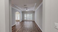 Located at 5375 Sugarloaf Pkwy in Lawrenceville, GA, this thoughtfully designed one-bedroom, one-bathroom residence offers a comfortable and stylish living experience across a single floor. The inviting living room features rich hardwood-style flooring, a tray ceiling with crown molding, a ceiling fan, and large windows that fill the space with natural light. A distinctive arched entryway with decorative columns connects the living area to the entrance, adding an elegant architectural touch. The kitchen is a standout, boasting rich cherry wood cabinetry, granite countertops, a sage green subway tile backsplash, stainless steel appliances, and a central island — ideal for both cooking and entertaining. The carpeted bedroom is generously sized, bathed in natural light from a large window, and equipped with a ceiling fan and a spacious walk-in closet with wire shelving for ample storage. The bathroom features a granite-topped white vanity, a large mirror, and hardwood-style flooring. A dedicated in-unit laundry room with a full-size washer and dryer adds everyday convenience. Neutral gray walls and consistent finishes throughout lend the space a clean, cohesive aesthetic.