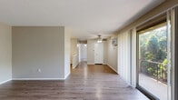 Located at 6500 Maplewood Rd in Mayfield Heights, OH, this one-bedroom, one-bathroom residence offers a practical and comfortable single-floor layout. The living room is a welcoming space highlighted by wood-style laminate flooring, neutral warm-toned walls, and a ceiling fan with integrated lighting. A large sliding glass door floods the room with natural light and opens to a view of lush greenery, while vertical blinds offer adjustable privacy. A wall-mounted HVAC unit and baseboard heating ensure year-round climate control. The kitchen is efficiently designed with white cabinetry, a range, and ample counter space, as seen in the dollhouse overview. The bedroom features plush wall-to-wall carpeting, a ceiling fan, a window with natural light and outdoor views, and a full-width sliding-door closet offering generous storage. The bathroom is neatly finished with wood-style flooring, a dark-toned vanity with cabinet storage, a full tub-shower combination with white tile surround, and brushed nickel fixtures. Throughout the unit, consistent neutral tones and clean finishes create a cohesive, move-in-ready atmosphere well-suited for comfortable everyday living.