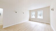 Located in the heart of Los Angeles, this thoughtfully designed 1-bedroom, 1-bathroom unit at 702 S Mariposa Ave offers a comfortable and refined living experience across a single floor. Light hardwood flooring flows consistently throughout, lending warmth and cohesion to every room.

The living room is generously proportioned, bathed in natural light from multiple double-hung windows framed in crisp white trim, and accented by classic wall sconces. Adjacent, the dedicated dining area provides a distinct space for meals and entertaining. The kitchen is well-equipped, featuring grey shaker-style cabinetry with beadboard detailing, rich quartz countertops, and a charming entry door with glass panes that offer views of lush outdoor greenery.

The spacious bedroom benefits from dual windows with garden views, creating a bright and serene retreat. A dedicated closet with built-in shelving provides ample storage. The bathroom is a standout feature, showcasing dramatic marble-style tile in the walk-in glass shower, a sleek wall-mounted dark vanity with matte black fixtures, a penny tile floor, and a natural light-filled window — all combining for a contemporary, upscale aesthetic. A hallway connects the rooms with ease, completing this well-organized and stylish home.