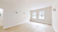 Located in the heart of Los Angeles, this thoughtfully designed 1-bedroom, 1-bathroom unit at 702 S Mariposa Ave offers a comfortable and refined living experience across a single floor. Light hardwood flooring flows consistently throughout, lending warmth and cohesion to every room.

The living room is generously proportioned, bathed in natural light from multiple double-hung windows framed in crisp white trim, and accented by classic wall sconces. Adjacent, the dedicated dining area provides a distinct space for meals and entertaining. The kitchen is well-equipped, featuring grey shaker-style cabinetry with beadboard detailing, rich quartz countertops, and a charming entry door with glass panes that offer views of lush outdoor greenery.

The spacious bedroom benefits from dual windows with garden views, creating a bright and serene retreat. A dedicated closet with built-in shelving provides ample storage. The bathroom is a standout feature, showcasing dramatic marble-style tile in the walk-in glass shower, a sleek wall-mounted dark vanity with matte black fixtures, a penny tile floor, and a natural light-filled window — all combining for a contemporary, upscale aesthetic. A hallway connects the rooms with ease, completing this well-organized and stylish home.