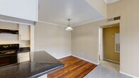 Located at 15530 Ella Blvd in Houston, TX, this single-floor residence offers a practical and well-organized layout encompassing one bedroom, three bathrooms, and dedicated laundry space. The open-concept kitchen and living room serve as the heart of the home, where rich hardwood flooring flows through the kitchen and dining area. The kitchen is outfitted with white cabinetry, dark granite-style countertops, black appliances including an electric range and refrigerator, and a double sink — all arranged in an efficient galley-style configuration. The living room features plush carpet, crown molding, a ceiling fan, a wood-paneled fireplace, and sliding glass doors that open onto a private balcony, filling the space with natural light and outdoor views. The spacious primary bedroom is carpeted and includes access to a dedicated closet with built-in shelving, along with a connecting bathroom. Two additional bathrooms serve the residence, one featuring a tub/shower combination with clean white tile surround. Three closets throughout provide generous storage. The entrance connects seamlessly to the main living areas, and warm neutral tones unify the interior, creating a cohesive and functional living environment.