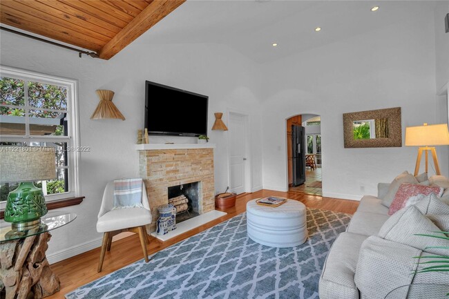 Living room invites you in with its decorative fireplace, bamboo covered sconces, white walls, vault - 1109 NE 3rd St