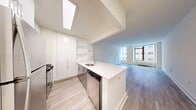 This sophisticated 1-bedroom apartment at 10 Hanover Square offers 740 square feet of meticulously designed living space in the heart of Manhattan's Financial District. The open-concept layout maximizes the use of space, featuring a combined kitchen and living area that flows seamlessly into the bedroom.

The kitchen is a chef's delight, boasting sleek white cabinetry, stainless steel appliances, and a stylish subway tile backsplash. The countertops are a crisp white, complementing the modern aesthetic. A breakfast bar provides additional seating and separates the kitchen from the living area.

The living room is bathed in natural light from large windows that offer stunning city views. The space is versatile, perfect for entertaining or relaxing after a long day. Light-toned hardwood floors run throughout the apartment, adding warmth and continuity to the space.

The bathroom is a study in contemporary design, featuring a floating vanity with ample storage, a large mirror, and a combination shower and tub with elegant tile work. The bedroom, at 220 square feet, is generously sized and includes a spacious closet for storage.

High ceilings and recessed lighting contribute to the apartment's airy feel, while the neutral color palette provides a blank canvas for personal touches. This turnkey residence offers modern urban living at its finest, combining style, comfort, and convenience in one of New York's most dynamic neighborhoods.