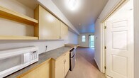 Located at 1100 NE 47th St in Seattle's University District, this efficiently designed unit makes smart use of its compact footprint across a single floor. The open layout connects the kitchenette and living area in one continuous space, maximizing functionality. The kitchenette is outfitted with light wood cabinetry, ample upper and lower storage, a laminate countertop, and a compact refrigerator and microwave — providing all the essentials in a streamlined galley-style arrangement. The carpeted living area is bright and clean, featuring neutral white walls and a sliding glass door that fills the room with natural light and provides direct access to the private balcony. An additional window further enhances the sense of openness. The balcony overlooks a shared courtyard framed by the surrounding building, offering a pleasant outdoor retreat. A closet provides dedicated storage, keeping the living space uncluttered. The full bathroom is finished in clean, all-white tones and includes a tub/shower combination, toilet, and tile flooring, delivering a practical and well-maintained space. Overall, the unit offers a straightforward, functional layout well-suited to urban living in a central Seattle neighborhood.