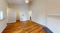 This single-story residence in Greenville, SC offers a well-designed layout with a variety of notable architectural and interior features. The living area immediately draws attention with its dramatic vaulted ceilings and warm hardwood flooring, creating an open, airy atmosphere. A ceiling fan with a light fixture provides overhead comfort, while a fireplace with a classic white mantel serves as a focal point. Sliding glass doors fitted with vertical blinds open directly to an outdoor deck, allowing natural light to fill the space and providing convenient access to the exterior.

The kitchen is efficiently arranged in a galley-style configuration, featuring dark cabinetry, granite countertops, stainless steel appliances including a range, microwave, and refrigerator, and a peninsula with an undermount sink. Track lighting illuminates the workspace, and hardwood flooring continues throughout. Louvered closet doors offer additional storage access.

The bedrooms are carpeted in neutral tones and receive natural light through windows fitted with blinds, contributing to a calm and comfortable environment. The bathroom includes a full tub and shower combination with white subway tile surround, hardwood flooring, and clean, functional fixtures throughout. The overall palette of warm beige tones and wood finishes lends a cohesive, understated character to the entire space.