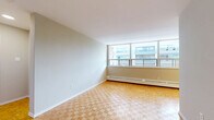 Located at 552 Birchmount Road, Suite 505 in Toronto's Scarborough neighbourhood, this one-bedroom, one-bathroom unit offers a practical and well-organized layout across a single floor. Warm parquet wood flooring runs consistently throughout the main living areas and bedroom, lending a classic character to the space.

The living room is generously proportioned and bathed in natural light through expansive floor-to-ceiling windows that frame views of the surrounding neighbourhood. A baseboard heating system runs along the window wall, ensuring comfort year-round. The open sightlines and neutral grey walls create a clean, versatile backdrop.

The bedroom is a comfortable size, featuring the same parquet flooring, soft grey walls, and a built-in sliding-door closet that offers practical storage. A doorway connects it directly to the hallway, contributing to a straightforward and efficient floor plan.

The kitchen is tucked neatly off the living area, outfitted with white cabinetry and tile flooring, providing a functional workspace. The bathroom is finished in crisp white tile, complete with a full bathtub and shower combination, toilet, and clean, minimal fixtures throughout.

A welcoming hallway connects the key areas of the unit, enhancing the sense of flow. Overall, the space presents a bright, tidy, and functional living environment well-suited for individuals or couples.