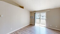 Located at 12423 E Mansfield Ave in Spokane Valley, WA, this two-bedroom, one-bathroom unit offers a practical and well-organized single-floor layout. The living room is bright and inviting, featuring light wood-style flooring, neutral beige walls, and a wall-mounted air conditioning unit. A sliding glass door opens to a private balcony, allowing natural light to fill the space and providing outdoor views of the surrounding neighborhood.

The kitchen and dining area are combined into one functional space, outfitted with warm oak cabinetry, dark speckled countertops, and white appliances including a gas range, microwave, and refrigerator. In-unit laundry access is conveniently located adjacent to the kitchen. A dedicated countertop area near the laundry provides additional workspace or storage.

Both bedrooms feature plush carpeting and windows that bring in natural light. The primary bedroom offers a comfortable footprint, while the second bedroom is well-sized and versatile. Each room includes neutral wall tones that create a calm, cohesive atmosphere throughout.

The bathroom includes an oak vanity with a granite-style countertop, a large mirror with overhead lighting, and wood-look flooring, completing the unit's consistent warm aesthetic. A dedicated closet provides additional storage.
