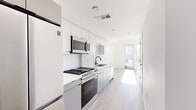 Located at 1100 Temple Ave in Los Angeles, this modern 1-bedroom, 1-bathroom unit offers a thoughtfully designed layout across a single floor. The open-concept living and dining area is bathed in natural light, highlighted by light wood-tone flooring and crisp white walls that create a clean, contemporary aesthetic. Floor-to-ceiling sliding glass doors lead to a private balcony, offering stunning views of the Los Angeles skyline—a standout feature of the space. A ceiling fan adds comfort to the airy living area.

The galley-style kitchen is well-appointed with stainless steel appliances including a gas range, microwave, and dishwasher, complemented by white cabinetry, a white subway tile backsplash, and a sleek countertop with a matte black faucet. The efficient layout maximizes every inch of the kitchen corridor.

The bedroom is a calm, light-filled retreat with the same wood-tone flooring and access to natural light. Two closets provide ample storage throughout the unit. The bathroom features bold dark hexagonal tile flooring contrasted against bright white walls, a soaking tub with shower, built-in shelving, and a clean vanity. In-unit laundry adds everyday convenience to this well-designed urban residence.
