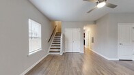 Located at 6554 Chupp Rd in DeKalb, GA, this two-story home offers a practical and well-designed layout across two floors. The main level houses the primary living areas, including a spacious living room with a ceiling fan, natural light from multiple windows, and durable hardwood-style flooring that flows throughout. A staircase with a wood railing leads to the upper level, and a closet on the main floor adds convenient storage. The combined dining room and kitchen area is a standout feature, showcasing rich dark-espresso cabinetry, granite countertops, and a full suite of black appliances, including a range, microwave, dishwasher, and refrigerator. The kitchen is brightened by a window and overhead lighting. The upper level hosts both bedrooms, each equipped with a ceiling fan and hardwood-style floors. The primary bedroom offers a comfortable footprint with closet access, while the second bedroom features a window with neighborhood views. Three closets are distributed throughout the home for ample storage. Two full bathrooms include tub-shower combinations with clean, white surrounds and tile flooring. Additional functional spaces include a laundry area, utility room, and two hallways connecting the layout efficiently.