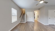 Located at 6554 Chupp Rd in DeKalb, GA, this two-story home offers a practical and well-designed layout across two floors. The main level houses the primary living areas, including a spacious living room with a ceiling fan, natural light from multiple windows, and durable hardwood-style flooring that flows throughout. A staircase with a wood railing leads to the upper level, and a closet on the main floor adds convenient storage. The combined dining room and kitchen area is a standout feature, showcasing rich dark-espresso cabinetry, granite countertops, and a full suite of black appliances, including a range, microwave, dishwasher, and refrigerator. The kitchen is brightened by a window and overhead lighting. The upper level hosts both bedrooms, each equipped with a ceiling fan and hardwood-style floors. The primary bedroom offers a comfortable footprint with closet access, while the second bedroom features a window with neighborhood views. Three closets are distributed throughout the home for ample storage. Two full bathrooms include tub-shower combinations with clean, white surrounds and tile flooring. Additional functional spaces include a laundry area, utility room, and two hallways connecting the layout efficiently.