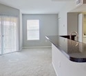 This contemporary 890 square foot apartment, located at 6231 Medici Ct in Sarasota, Florida, offers a blend of comfort and functionality. The single-story layout comprises two bedrooms, including a spacious primary bedroom of 280 square feet, two closets for ample storage, and an open-concept kitchen and living room area.

The kitchen showcases modern amenities with wooden cabinetry, granite countertops, and stainless steel appliances, including a built-in microwave and electric range. The living area seamlessly connects to the kitchen, creating an ideal space for entertaining or relaxation.

Throughout the apartment, neutral-toned walls and plush carpeting create a warm, inviting atmosphere. Large windows in the bedrooms and living area allow for abundant natural light, while ceiling fans provide additional comfort. Sliding glass doors in the living room lead to an outdoor space, extending the living area and offering a connection to the exterior environment.

The bedrooms are generously sized, with the primary bedroom featuring a vaulted ceiling for added spaciousness. Both closets are equipped with wire shelving systems for optimized organization. The bathroom, glimpsed in one image, appears to have modern fixtures and a granite countertop, consistent with the kitchen's aesthetic.

This well-designed apartment combines modern amenities with a practical layout, making it an attractive option for those seeking a contemporary living space in Sarasota.