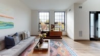 Located at 85 Arch St in Hartford, CT, this contemporary two-floor residence offers a thoughtfully designed layout with modern finishes throughout. The open living area is bathed in natural light from large, grid-paned windows that frame views of the surrounding neighborhood, complementing the warm light wood flooring that flows seamlessly through the main level. The kitchen is a standout feature, outfitted with rich dark cabinetry, white countertops, a full suite of stainless steel appliances, and a freestanding island with bar seating — ideal for casual dining and entertaining. The living room offers a comfortable, airy atmosphere with clean white walls and ample space for relaxing. The bedrooms are carpeted for warmth and comfort; one features a bold teal accent wall and large windows with outdoor views, while the second-floor bedroom provides a peaceful retreat with soft neutral tones. Two bathrooms serve the residence — one with a tub-shower combination and dark tile flooring, and another with a walk-in shower, granite-topped vanity, and elegant tile surround. A dedicated in-unit laundry room with a full-size washer and dryer adds everyday convenience. A staircase with metal railings connects the two levels, completing this well-appointed urban home.
