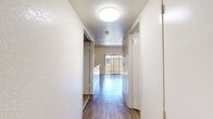 This 920-square-foot, two-bedroom, two-bathroom apartment at Pointe at Harden Ranch in Salinas, CA is thoughtfully laid out across two floors. The main floor spans 580 square feet and centers around an open living room featuring striking vaulted ceilings, wood-style flooring, and a tile-surround fireplace that serves as a focal point of the space. Sliding glass doors with vertical blinds allow natural light to fill the room and provide outdoor access. The kitchen is well-appointed with rich wood cabinetry, a gas range, stainless steel appliances including a dishwasher and refrigerator, a double-basin sink, and a breakfast bar with pass-through visibility to the living area. The upper floor encompasses 340 square feet and hosts both bedrooms, each with plush carpeting and sliding glass doors for natural light. The spacious primary bedroom measures 240 square feet and features vaulted ceilings and a dedicated walk-in closet with built-in shelving. Two full bathrooms serve the unit — one with a shower/tub combo and wood-style flooring, and a second with similar finishes. Two closets throughout the home provide ample storage. This well-designed unit combines functional living spaces with comfortable residential features.
