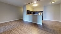 Located at 4500 Linden Hill Rd in Wilmington, Delaware, this single-floor residence offers a well-designed layout with a seamless blend of modern finishes and functional living spaces. The open-concept living and dining area is anchored by warm wood-look luxury vinyl plank flooring, neutral gray walls, and track lighting that enhances the airy, welcoming ambiance. A peninsula counter transitions into the kitchen, which is equipped with dark espresso cabinetry, granite countertops, and a full suite of stainless steel appliances including a refrigerator, electric range, and over-the-range microwave. The spacious bedrooms are finished with plush neutral carpeting and feature generous double-door closets and elevated ceilings that contribute to an open, comfortable feel. One bedroom benefits from dual windows that invite natural light and offer outdoor views. Both full bathrooms are appointed with beige tile flooring, tile-surround soaking tubs with shower combinations, chrome fixtures, and vanities with white countertops. Throughout the unit, clean white trim and baseboards provide a crisp contrast to the soft gray walls, resulting in a cohesive and contemporary aesthetic well-suited for modern living.