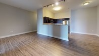Located at 4500 Linden Hill Rd in Wilmington, Delaware, this single-floor residence offers a well-designed layout with a seamless blend of modern finishes and functional living spaces. The open-concept living and dining area is anchored by warm wood-look luxury vinyl plank flooring, neutral gray walls, and track lighting that enhances the airy, welcoming ambiance. A peninsula counter transitions into the kitchen, which is equipped with dark espresso cabinetry, granite countertops, and a full suite of stainless steel appliances including a refrigerator, electric range, and over-the-range microwave. The spacious bedrooms are finished with plush neutral carpeting and feature generous double-door closets and elevated ceilings that contribute to an open, comfortable feel. One bedroom benefits from dual windows that invite natural light and offer outdoor views. Both full bathrooms are appointed with beige tile flooring, tile-surround soaking tubs with shower combinations, chrome fixtures, and vanities with white countertops. Throughout the unit, clean white trim and baseboards provide a crisp contrast to the soft gray walls, resulting in a cohesive and contemporary aesthetic well-suited for modern living.