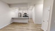 This contemporary apartment in Charlotte, NC, offers 1070 square feet of well-designed living space. The open-concept floor plan seamlessly integrates the kitchen, dining, and living areas, creating a spacious feel. The kitchen boasts modern white cabinets, stainless steel appliances, and an expansive granite countertop with a breakfast bar.

Both bedrooms are generously sized, with the primary bedroom measuring 200 square feet. The two full bathrooms feature sleek vanities with granite countertops and modern fixtures. The apartment includes a convenient in-unit laundry room with a full-size washer and dryer.

Throughout the space, wood-look flooring adds warmth and durability. Large windows allow ample natural light, while ceiling fans and air conditioning units ensure comfort year-round. The apartment also features a walk-in closet for additional storage.

Located at 1921 Lamm Dr in Charlotte's 28262 zip code, this single-story apartment combines modern amenities with a practical layout, perfect for comfortable city living.