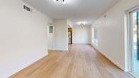 Located at 3120 S Frontage Rd in Vicksburg, Mississippi, this 2-bedroom, 1-bathroom single-floor unit offers a clean, modern aesthetic with a bright and cohesive design throughout. Light wood-style flooring flows seamlessly across every room, complementing the crisp white walls and trim that give the space an open, airy feel.

The combined living and dining area is generously sized, featuring multiple windows and sliding glass doors that flood the space with natural light and provide views of the surrounding greenery. A modern track light fixture accents the ceiling, adding a contemporary touch.

The kitchen is well-appointed with two-tone cabinetry — warm taupe lower cabinets paired with white uppers — a classic subway tile backsplash, stainless steel appliances including a dishwasher, microwave, and range, and recessed lighting overhead.

Both bedrooms are comfortably proportioned, each featuring ceiling fans, large windows that bring in natural light, and ample closet space with sliding closet doors. The primary bedroom offers a particularly spacious layout.

The bathroom includes a full tub and shower combination with stylish white and tan patterned tile surround and warm brass fixtures. A dedicated laundry area and multiple closets throughout add to the unit's practical functionality.