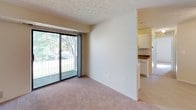 This single-floor unit offers a practical and comfortable layout designed to maximize functionality. The kitchen is configured in a galley style, featuring white cabinetry with ample upper and lower storage, dark granite-style countertops, a dishwasher, an electric range, and a refrigerator. A window above the sink allows natural light to brighten the workspace. The kitchen connects seamlessly to the living area via a half-wall pass-through, creating an open, connected feel.

The living room is carpeted and bathed in natural light from a large sliding glass door that opens onto a private balcony. The balcony overlooks a well-maintained, fenced green space shaded by mature trees, offering a pleasant outdoor retreat. A textured ceiling adds subtle architectural character to the living area.

The bedroom is generously proportioned with soft carpet flooring, a natural light window, and notable closet space, including both standard and walk-in style closets offering excellent storage capacity.

The full bathroom includes a tub-shower combination with a window for ventilation and natural light, complemented by tile-style flooring. Throughout the unit, neutral tones and practical finishes create a clean, move-in-ready atmosphere.
