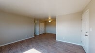Located at 4195 W 72nd Ave in Westminster, Colorado, this single-floor unit offers a practical and well-organized layout suited for comfortable everyday living. The living area features light wood-style hard-surface flooring that extends throughout the main spaces, complemented by neutral-toned walls that create a clean, versatile backdrop. Natural light filters in through windows, enhancing the open feel of the space.

The kitchen is outfitted with warm honey-toned wooden cabinetry offering generous storage, dark countertops, and a full suite of black appliances including a refrigerator, electric range, dishwasher, and overhead ventilation. Light wood-style flooring ties the kitchen together and provides an easy-to-maintain surface.

The bedrooms are carpeted for comfort and feature wall-mounted air conditioning units and baseboard heating, ensuring year-round climate control. Multiple windows allow natural light into the sleeping areas. One bedroom includes a double-door closet for organized storage.

The bathroom is appointed with wood-style flooring, a single vanity with granite-style countertop, and a full tub and shower combination with a window above for ventilation. The unit's neutral palette and functional layout make it an adaptable space in a residential Westminster neighborhood.
