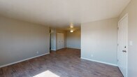 Located at 4195 W 72nd Ave in Westminster, Colorado, this single-floor unit offers a practical and well-organized layout suited for comfortable everyday living. The living area features light wood-style hard-surface flooring that extends throughout the main spaces, complemented by neutral-toned walls that create a clean, versatile backdrop. Natural light filters in through windows, enhancing the open feel of the space.

The kitchen is outfitted with warm honey-toned wooden cabinetry offering generous storage, dark countertops, and a full suite of black appliances including a refrigerator, electric range, dishwasher, and overhead ventilation. Light wood-style flooring ties the kitchen together and provides an easy-to-maintain surface.

The bedrooms are carpeted for comfort and feature wall-mounted air conditioning units and baseboard heating, ensuring year-round climate control. Multiple windows allow natural light into the sleeping areas. One bedroom includes a double-door closet for organized storage.

The bathroom is appointed with wood-style flooring, a single vanity with granite-style countertop, and a full tub and shower combination with a window above for ventilation. The unit's neutral palette and functional layout make it an adaptable space in a residential Westminster neighborhood.