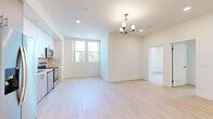Located at 8521 Sepulveda Blvd in Los Angeles, this thoughtfully designed 2-bedroom, 2-bathroom unit offers a clean, contemporary aesthetic throughout. Light-toned hardwood flooring flows seamlessly across the entire space, lending warmth and visual continuity to every room. The open living and dining area is bathed in natural light from large windows and accented by an elegant chandelier with recessed lighting overhead, creating a welcoming and airy atmosphere. The kitchen is well-appointed with stainless steel appliances including a refrigerator, electric range, built-in microwave, and dishwasher, complemented by white upper cabinetry, gray lower cabinets, and a glossy subway tile backsplash. Both bedrooms are generously proportioned with mirrored sliding closet doors that enhance the sense of space. The two bathrooms are finished in a clean, neutral palette — one featuring a tub-shower combination with gray tile surround, and the primary bath offering a wide vanity with quartz countertop, a large mirror, and a separate soaking tub. Recessed lighting and white walls throughout contribute to a bright, modern ambiance that is both functional and refined.