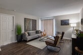 Located at 695 Pineloch Dr in Houston, TX, this single-floor residence offers a thoughtfully designed layout with a cohesive modern aesthetic carried throughout every room. The kitchen is efficiently arranged with dark espresso cabinetry, granite-style countertops, and a full suite of black appliances including an electric range, over-the-range microwave, and refrigerator. Rich wood-look flooring runs through the kitchen and main living areas, adding warmth and visual continuity. The living room is spacious and inviting, featuring a sliding glass door with vertical blinds that allows natural light to filter in and provides access to the outdoors. The dining area accommodates a full-sized wooden table with seating for four, complemented by neutral gray walls. Each bedroom is carpeted for comfort and equipped with a ceiling fan and windows that bring in ample natural light. The bedrooms offer a calm, restful atmosphere suitable for relaxation. The bathroom features a granite-style vanity with dark cabinetry consistent with the rest of the home, wood-look flooring, and a separate water closet with a shower/tub combination. Overall, the residence presents a clean, modern style with a consistent use of dark tones and natural textures throughout.
