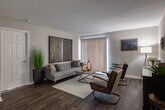 Located at 695 Pineloch Dr in Houston, TX, this single-floor residence offers a thoughtfully designed layout with a cohesive modern aesthetic carried throughout every room. The kitchen is efficiently arranged with dark espresso cabinetry, granite-style countertops, and a full suite of black appliances including an electric range, over-the-range microwave, and refrigerator. Rich wood-look flooring runs through the kitchen and main living areas, adding warmth and visual continuity. The living room is spacious and inviting, featuring a sliding glass door with vertical blinds that allows natural light to filter in and provides access to the outdoors. The dining area accommodates a full-sized wooden table with seating for four, complemented by neutral gray walls. Each bedroom is carpeted for comfort and equipped with a ceiling fan and windows that bring in ample natural light. The bedrooms offer a calm, restful atmosphere suitable for relaxation. The bathroom features a granite-style vanity with dark cabinetry consistent with the rest of the home, wood-look flooring, and a separate water closet with a shower/tub combination. Overall, the residence presents a clean, modern style with a consistent use of dark tones and natural textures throughout.