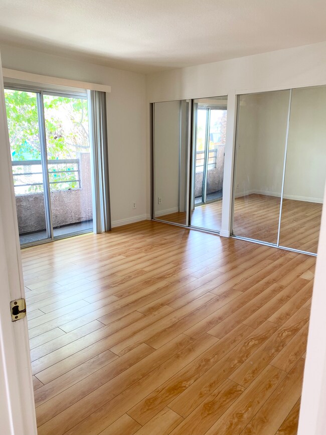 Dormitorio principal con balcón y armarios dobles. - 158 N Normandie Ave