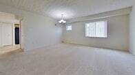 This 880 square foot apartment, located at 4742 Centre Ave in Pittsburgh, offers a blend of comfort and functionality. The single-floor layout comprises one bedroom, one bathroom, a kitchen, a utility room, and a hallway. The primary bedroom is generously sized at 200 square feet, providing ample space for relaxation and storage.

The living areas are adorned with plush wall-to-wall carpeting, creating a cozy atmosphere. Large windows in the bedroom and living space allow natural light to flood in, while offering views of the surrounding urban landscape. The ceilings feature a distinctive paneled design, adding character to the space.

The kitchen is a highlight, boasting wooden cabinetry, black appliances, and a practical L-shaped layout. It features a gas range, refrigerator, and ample counter space. The wood-look flooring in the kitchen adds warmth and contrasts nicely with the carpeted areas.

The bathroom, while not pictured, likely continues the apartment's modern aesthetic. A utility room adds convenience for laundry and storage needs. The hallway connects the rooms efficiently, maintaining an open feel throughout the apartment.

Overall, this Pittsburgh apartment combines urban living with comfortable amenities, making it an attractive option for singles or couples seeking a well-appointed city dwelling.