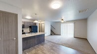 Located at 1040 Blue Ridge Pl NW in Altoona, Iowa, this two-story home offers three bedrooms, three bathrooms, and a practical, well-organized layout across two floors. The main level features an open-concept kitchen and living area with wood-look flooring that transitions into plush carpeting in the living space. The kitchen is equipped with dark cabinetry, stainless steel appliances including a refrigerator, range, and microwave, a double-basin sink set into a peninsula countertop, and pendant lighting overhead. A pantry provides additional storage convenience. The living room is bright and comfortable, highlighted by a ceiling fan, a large sliding glass door with vertical blinds that invites natural light and outdoor views, and direct access to the staircase leading to the upper level. The upper floor hosts all three bedrooms, each carpeted and fitted with windows for natural light. The primary bedroom features a ceiling fan and ample closet space. Three full bathrooms are distributed throughout the home, each finished with tile flooring, light countertops, dark vanity cabinetry, and tub-shower combinations. A dedicated laundry room and five closets throughout the home add to its functional appeal. Textured ceilings are consistent throughout, giving the space a classic, well-kept character.