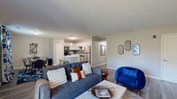 Located at 7266 Lockwood Ln in Indianapolis, Indiana, this single-story 2-bedroom, 2-bathroom home offers a thoughtfully designed open-concept layout. The combined living room and kitchen area serves as the heart of the home, featuring durable wood-look flooring, neutral walls, and a textured ceiling throughout. The living room is bright and welcoming, with a sliding glass door that opens to an outdoor deck, allowing natural light to fill the space.

The kitchen is well-equipped with white shaker-style cabinetry, a grey subway tile backsplash, stainless steel appliances including a refrigerator, range, microwave, and dishwasher, and a central island with a white countertop that provides both prep space and bar seating. A dedicated dining area sits adjacent to the kitchen, making the open layout ideal for everyday living and entertaining.

The primary bedroom offers a comfortable retreat with a natural light-filled window, wood-look flooring, a walk-in closet, and direct access to a private en-suite bathroom. The en-suite features a glass-enclosed walk-in shower and white vanity cabinetry. A second bedroom and additional full bathroom serve guests or household members. A hallway connects the private spaces efficiently, completing this functional and modern single-floor home.