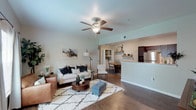 This single-story, two-bedroom, two-bathroom residence offers a thoughtfully designed layout that balances functionality with a clean, contemporary aesthetic. The open-concept living area features dark hardwood-style flooring, neutral wall tones, and a ceiling fan overhead, creating a comfortable and inviting atmosphere. Natural light filters in through windows dressed with curtain panels, brightening the space throughout the day.

The kitchen is equipped with dark espresso cabinetry, granite-style countertops, stainless steel appliances including a refrigerator and range, and a built-in sink, providing ample workspace and storage. It opens directly to the dining area, which includes a dedicated in-unit laundry closet housing a full-size washer and dryer. Rustic floating shelves add a decorative touch to the dining space.

Both bedrooms feature plush carpet, ceiling fans, and closets with built-in shelving. The primary bedroom is generously proportioned with a window allowing natural light. Each of the two bathrooms is finished with dark vanity cabinetry, granite-style countertops, a large mirror, and a tub/shower combo tiled with classic white subway tile, lending a timeless, polished look throughout.