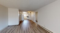 Located at 513 C St in Washougal, Washington, this single-floor, 3-bedroom, 1-bathroom home offers a practical and well-organized layout. The open living area is finished with wood-look laminate flooring that runs throughout the home, complemented by a textured ceiling and a ceiling fan with light fixture. Baseboard heating is present throughout, ensuring year-round comfort. A sliding glass door with vertical blinds in the living room allows natural light to fill the space.

The kitchen is efficiently designed in a galley-style configuration, featuring white cabinetry, dark countertops, a white electric range, and a full-size refrigerator. A window above the sink brings in additional natural light, enhancing the bright, clean aesthetic.

The three bedrooms are comfortably sized, with the primary bedroom offering a walk-in closet with a full-width hanging rod. Each bedroom features the same wood-look flooring and neutral wall tones found throughout the home.

The bathroom is well-appointed with a dark granite-style countertop, white cabinetry with ample storage, a large vanity mirror, and a tub-shower combination. The consistent use of light, neutral tones and wood-look flooring throughout the home creates a cohesive and clean aesthetic.