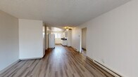 Located at 513 C St in Washougal, Washington, this single-floor, 3-bedroom, 1-bathroom home offers a practical and well-organized layout. The open living area is finished with wood-look laminate flooring that runs throughout the home, complemented by a textured ceiling and a ceiling fan with light fixture. Baseboard heating is present throughout, ensuring year-round comfort. A sliding glass door with vertical blinds in the living room allows natural light to fill the space.

The kitchen is efficiently designed in a galley-style configuration, featuring white cabinetry, dark countertops, a white electric range, and a full-size refrigerator. A window above the sink brings in additional natural light, enhancing the bright, clean aesthetic.

The three bedrooms are comfortably sized, with the primary bedroom offering a walk-in closet with a full-width hanging rod. Each bedroom features the same wood-look flooring and neutral wall tones found throughout the home.

The bathroom is well-appointed with a dark granite-style countertop, white cabinetry with ample storage, a large vanity mirror, and a tub-shower combination. The consistent use of light, neutral tones and wood-look flooring throughout the home creates a cohesive and clean aesthetic.