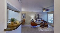 This thoughtfully designed one-bedroom, one-bathroom residence offers a practical and comfortable single-floor layout. The living room serves as the heart of the home, featuring plush carpeting, a ceiling fan, a classic fireplace framed by two windows that invite natural light, and an open sightline to the kitchen — making the space feel open and connected. The kitchen is efficiently appointed with white cabinetry, dark granite-style countertops, black appliances, and wood-look flooring, providing ample storage and workspace. A pass-through window connects the kitchen to the living and dining area, enhancing the open feel. The bedroom is a generous, carpeted retreat equipped with a ceiling fan, sliding glass door access to an outdoor space, and views to the exterior. It is complemented by a walk-in closet outfitted with built-in shelving and hanging rods. The bathroom features a single vanity with a granite-style countertop, white cabinetry, and a large mirror. Additional conveniences include a dedicated laundry area. Throughout the residence, neutral tones, textured ceilings, and consistent finishes create a cohesive and inviting atmosphere.