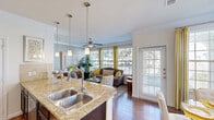 Located in Austin, TX, this well-appointed 1-bedroom, 1-bathroom residence offers a thoughtfully designed open-concept layout that seamlessly connects the kitchen, dining, and living areas. Rich hardwood flooring runs throughout, complemented by crown molding that adds a refined architectural touch.

The kitchen is a standout, featuring dark espresso cabinetry, gleaming granite countertops, stainless steel appliances, a double-basin sink, and a breakfast bar with seating — ideal for casual dining or entertaining. Pendant lighting and track lighting provide both style and function.

The living room is bright and welcoming, with large windows that flood the space with natural light and offer outdoor views. A ceiling fan adds comfort, while direct access to a private exterior door enhances convenience.

The dining area benefits from its own set of oversized windows and a private entrance, creating an airy, sun-filled atmosphere. The spacious primary bedroom includes a dedicated walk-in closet and large windows, offering a serene retreat.

The bathroom is finished with granite countertops, dark cabinetry, hardwood-style flooring, and a full tub-shower combination with floor-to-ceiling tile surround. Every room reflects a cohesive, modern aesthetic throughout.