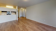 This single-floor unit offers a thoughtfully designed layout with a clean, neutral color palette and a mix of durable flooring throughout. The open living area is finished with warm hardwood-style flooring, offering a welcoming and versatile space. Large windows fitted with blinds allow natural light to fill the rooms, including the generously sized bedrooms, which feature plush wall-to-wall carpeting for added comfort.

The kitchen is well-equipped and features rich dark cabinetry paired with crisp white countertops, a tile backsplash, and stainless steel appliances including a range, microwave, and refrigerator. A pass-through counter connects the kitchen to the living area, enhancing the open feel of the space.

Two bathrooms serve the unit. One bathroom includes a sliding glass-door shower enclosure, a dark-cabinetry vanity, and hardwood-style flooring. The second bathroom offers a wide vanity with ample counter space, a large mirror, dark cabinetry with brushed hardware, and accessible grab bars, reflecting a practical and inclusive design.

The bedrooms are spacious, with one featuring direct access to the en-suite bathroom and a closet. Throughout the unit, the consistent use of warm tones, clean lines, and functional finishes creates a cohesive and comfortable living environment.