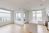 Located at 1500 Irving St in Denver's vibrant 80204 neighborhood, this modern 2-bedroom, 2-bathroom residence offers a thoughtfully designed single-floor layout filled with clean lines and contemporary finishes. The open-concept kitchen and living area serves as the heart of the home, featuring light hardwood flooring, recessed lighting, and expansive floor-to-ceiling windows that frame sweeping city and mountain views. The kitchen is outfitted with white flat-front cabinetry, a penny-tile backsplash, stainless steel appliances, and a central island with quartz countertops. The primary bedroom is generously sized with large windows offering elevated views of the Denver skyline, complemented by plush carpeting and a dedicated walk-in closet with built-in shelving. The second bedroom similarly benefits from abundant natural light and hardwood flooring. Both bathrooms feature modern floating vanities with gray countertops, wood-tone flooring, and clean tile work in the shower and tub surround. A discreet closet in the hallway houses a stacked in-unit washer and dryer, adding everyday convenience. The bright, neutral palette and thoughtful layout create a cohesive, functional living environment with a polished urban aesthetic.