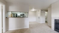 This single-floor unit offers a thoughtfully laid-out interior designed for comfortable everyday living. The living room serves as the heart of the space, featuring a classic tile-surround fireplace and a large window fitted with blinds that fills the room with natural light. Plush carpeting extends throughout the living area and into the bedrooms, lending a warm and cozy feel underfoot.

The kitchen is positioned adjacent to the living area and is accessible via a pass-through counter, creating an open and connected atmosphere. It is outfitted with white cabinetry, dark granite-style countertops, a stainless steel refrigerator, and a stainless steel electric range with a range hood. The kitchen flooring features wood-look planks, providing a clean contrast to the surrounding carpeted spaces.

The entryway welcomes residents with tile flooring and a large window beside the front door, allowing for ample natural light at the entrance.

The bedrooms are carpeted and feature neutral-toned walls, offering a calm retreat. Each bedroom includes a walk-in or reach-in closet with built-in shelving and hanging rods for organized storage.

Two bathrooms serve the unit, each featuring white cabinetry with dark countertops, overhead storage, and wood-look plank flooring. One bathroom includes a tiled shower, while the other is appointed with a tub-shower combination.