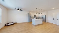 Located at 24400 E Patterson Place in Aurora, CO, this two-story home offers a thoughtfully designed layout across two floors. The main level features an open-concept kitchen and living area with light hardwood-style flooring, a ceiling fan, and generous natural light from large windows with views of the surrounding neighborhood. The kitchen is a standout, equipped with stainless steel appliances, two-tone gray and white shaker cabinetry, a subway tile backsplash, a large center island with a white quartz countertop, and stylish matte black and brass pendant lighting. The attached garage provides ample space with a full automatic door opener and direct interior access. An in-unit laundry room houses a full-size side-by-side washer and dryer. The upper floor contains all three bedrooms, including a spacious primary bedroom with plush carpeting and a dedicated en-suite bathroom. The primary bath features wood-look flooring, an illuminated LED vanity mirror, dual-sink cabinetry with matte black hardware, and a clean, modern aesthetic. The additional bathrooms echo this contemporary style with neutral tile accents and bright, windowed layouts. Secondary bedrooms are carpeted and include ceiling fans and natural light.