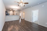 Located at 2902 Milwaukee Ave in Lubbock, Texas, this single-story home offers a thoughtfully designed open-concept layout that seamlessly connects the main living areas. The entryway welcomes you with rich wood-look flooring that extends throughout the common areas, complemented by neutral gray walls and clean white trim.

The living and dining area is bright and open, anchored by an elegant chandelier and flowing naturally into the kitchen via a raised breakfast bar with granite countertops and seating brackets. The kitchen is well-equipped with dark espresso cabinetry, granite countertops, pendant lighting, and a full suite of black appliances including a range, microwave, and refrigerator — all arranged in a practical L-shaped configuration.

The bedrooms feature plush carpet flooring, ceiling fans, and windows that allow natural light to filter in through blinds. Each room provides a comfortable and quiet retreat with ample wall space and functional closet access.

The bathrooms are finished with consistent dark cabinetry, granite-topped vanities, framed mirrors, and wood-look flooring. One bathroom includes a tub-shower combo, while another offers a more compact layout. An electrical panel is conveniently accessible near the main living area. Overall, the home presents a cohesive, modern aesthetic throughout.