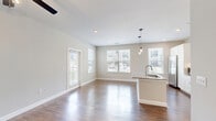 Located at 24500 Wildwood Park Rd in Richmond, TX, this well-appointed single-story home offers two bedrooms, two bathrooms, and a thoughtfully designed layout. The open-concept kitchen and living area serves as the heart of the home, showcasing white shaker cabinetry, granite countertops, stainless steel appliances, a central island with pendant lighting, and recessed ceiling lights — all complemented by warm wood-look flooring that extends throughout the home. The primary bedroom is generously sized, featuring dual windows that invite ample natural light and views of the greenery outside, along with a ceiling fan for added comfort. It is accompanied by a walk-in closet with built-in shelving and hanging rods, and a full en-suite bathroom complete with a granite vanity, white cabinetry, and a tiled tub-shower combination. The second bedroom also benefits from natural light and easy access to the second full bathroom. A private balcony offers outdoor views of landscaped grounds and community greenspaces. The attached garage includes an automatic door opener and fluorescent lighting, providing practical storage and parking. Neutral wall tones and clean white trim throughout lend a fresh, modern aesthetic to the entire home.