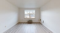 Located at 1323 SW Cherry Park Rd in Troutdale, Oregon, this two-bedroom, one-bathroom single-floor unit offers a clean, modern aesthetic throughout. Light wood-tone flooring flows seamlessly across all living areas, creating a bright and cohesive feel. The open-concept kitchen, dining, and living area serves as the heart of the home. The kitchen is well-appointed with light maple cabinetry, white countertops, a stainless steel refrigerator, dishwasher, and electric range, providing ample functionality. Natural light is a defining feature of this unit, with large windows in the living area and both bedrooms framing views of the surrounding Troutdale neighborhood. The spacious primary bedroom offers generous proportions, light flooring, and a wall-mounted HVAC unit. The second bedroom is equally bright with its own large window and closet access. Three closets throughout the unit provide notable storage. The bathroom is finished with white cabinetry, a built-in vanity, white countertop, and a backlit LED mirror that adds a modern, polished touch. A hallway connects the rooms efficiently, completing this well-designed, move-in-ready layout.