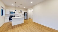 This contemporary 770 square foot apartment offers a well-designed living space with two bedrooms and two bathrooms. The open-concept layout maximizes the use of space, creating a seamless flow between the kitchen, dining, and living areas. The kitchen boasts white cabinetry, stainless steel appliances, and a convenient breakfast bar, complemented by stylish blue pendant lighting.

Throughout the apartment, large windows allow ample natural light to flood in, enhancing the sense of spaciousness. The primary bedroom, measuring 120 square feet, provides a cozy retreat with carpeted flooring and a generous closet space. The second bedroom also features carpet and offers flexibility for use as a guest room or home office.

Both bathrooms are equipped with modern fixtures, including a bathtub-shower combination, and feature a mix of hardwood and tile flooring. The apartment's flooring alternates between warm hardwood in the main living areas and plush carpeting in the bedrooms, adding texture and comfort.

A hallway connects the various rooms, ensuring easy navigation throughout the space. The apartment's neutral color palette, primarily in whites and light tones, creates a blank canvas for personal decor styles. With its thoughtful design and efficient use of space, this apartment offers a comfortable and contemporary urban living experience.