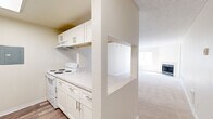 Located in Seattle's Lake City neighborhood, this single-floor, 2-bedroom, 2-bathroom residence offers a practical and comfortable layout. The kitchen is outfitted with white cabinetry, marble-style countertops, and white appliances, and connects to the living area via a convenient pass-through counter — ideal for entertaining or everyday convenience. The living room is bright and spacious, featuring plush carpeting, a classic fireplace, natural light from large windows, and a glass door leading to a private outdoor balcony. Both bedrooms are well-proportioned and carpeted, each with windows that invite natural light. The primary bedroom offers a comfortable retreat with its own closet. Both bathrooms are finished with wood-look vinyl flooring, tiled tub-and-shower surrounds, and marble-style vanity countertops, providing a clean and cohesive aesthetic. Two closets offer ample storage throughout the unit. The interior palette of neutral beige and white tones creates a calm, cohesive atmosphere throughout. With its functional open-concept design and thoughtful finishes, this residence delivers a comfortable living experience in a convenient Seattle location.