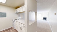 Located in Seattle's Lake City neighborhood, this single-floor, 2-bedroom, 2-bathroom residence offers a practical and comfortable layout. The kitchen is outfitted with white cabinetry, marble-style countertops, and white appliances, and connects to the living area via a convenient pass-through counter — ideal for entertaining or everyday convenience. The living room is bright and spacious, featuring plush carpeting, a classic fireplace, natural light from large windows, and a glass door leading to a private outdoor balcony. Both bedrooms are well-proportioned and carpeted, each with windows that invite natural light. The primary bedroom offers a comfortable retreat with its own closet. Both bathrooms are finished with wood-look vinyl flooring, tiled tub-and-shower surrounds, and marble-style vanity countertops, providing a clean and cohesive aesthetic. Two closets offer ample storage throughout the unit. The interior palette of neutral beige and white tones creates a calm, cohesive atmosphere throughout. With its functional open-concept design and thoughtful finishes, this residence delivers a comfortable living experience in a convenient Seattle location.