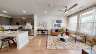 This thoughtfully designed 1-bedroom, 1-bathroom residence offers an efficient and functional single-floor layout with modern finishes throughout. The open-concept kitchen and living area serves as the heart of the home, featuring light hardwood-style flooring that flows seamlessly throughout the space. The kitchen is outfitted with rich dark-toned shaker cabinets, granite countertops, a white subway tile backsplash, a center island with seating, and a full suite of stainless steel appliances including a range, microwave, dishwasher, and refrigerator. The living area is bright and welcoming, with large windows and a glass door that invite abundant natural light and provide outdoor views. A ceiling fan adds comfort overhead. The bedroom is a comfortable retreat, featuring dual windows, a ceiling fan, and generous wall space. The bathroom includes a granite-topped vanity with dark cabinetry, a soaking tub, and clean, neutral finishes. A walk-in closet with multi-tier wire shelving provides practical storage. The overall ambiance of the space is modern and cohesive, combining neutral tones with warm wood accents for a polished, contemporary feel.