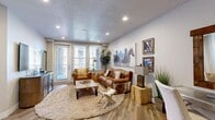 Located on W 300 N in Salt Lake City, Utah, this one-bedroom, one-bathroom residence offers a thoughtfully designed single-floor layout with a cohesive blend of modern finishes and rustic Western-inspired character. The living room is a welcoming focal point, featuring wood-look flooring, recessed lighting, large windows that invite natural light, and a glass-paneled door providing access to an outdoor area. The space is anchored by warm tones and eclectic decor, including large equestrian wall art that adds a distinctive artistic touch. The kitchen is well-equipped and contemporary, showcasing rich walnut-toned cabinetry, a subway tile backsplash, white quartz countertops, stainless steel appliances, and a peninsula with bar seating illuminated by pendant lighting — ideal for both cooking and casual dining. The spacious primary bedroom features plush carpeting, natural light from large windows, and direct sightlines to a dedicated workspace area. A walk-in closet provides generous storage. The bathroom offers a clean, modern design with a wood-faced vanity, white quartz countertop, and a shower-tub combination. Throughout the residence, consistent wood-look flooring, neutral walls, and recessed lighting create a cohesive and inviting atmosphere.